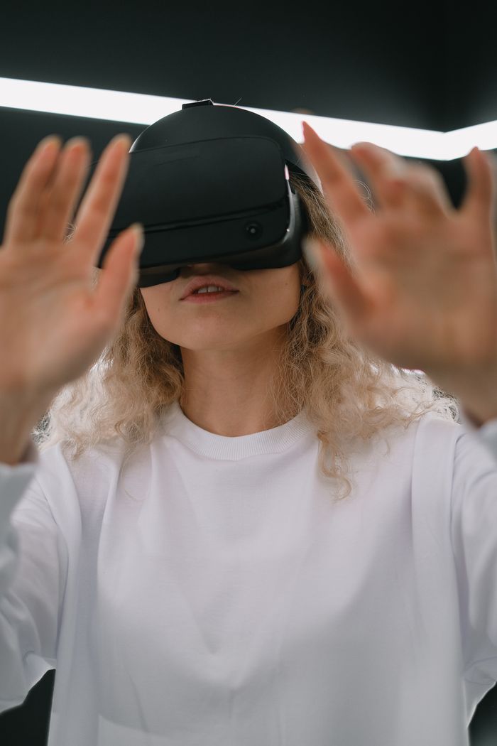 Blonde woman wearing VR headset indoors, exploring virtual reality.