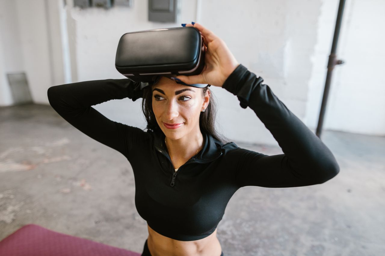 Smiling woman using virtual reality headset in a modern indoor setting.